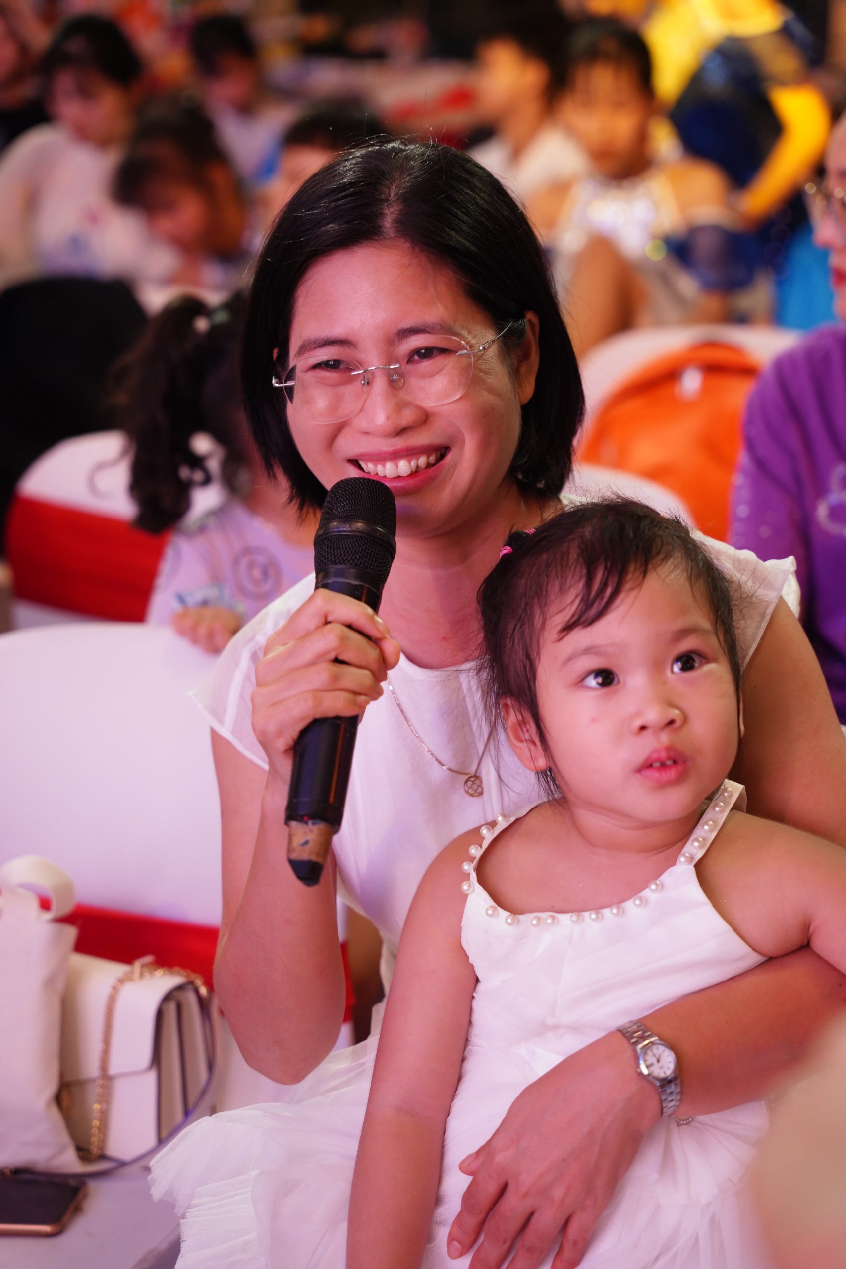 The smile of a mother with a grown child singing on stage, while a younger sibling cheers her on with all their might. That smile only blooms when the audience stands up to applaud after her child finishes singing.